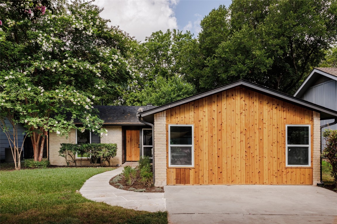 View of front facade featuring a front yard and roof with shingles