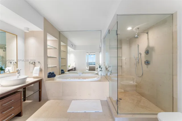 a bathroom with a tub sink mirror and shower