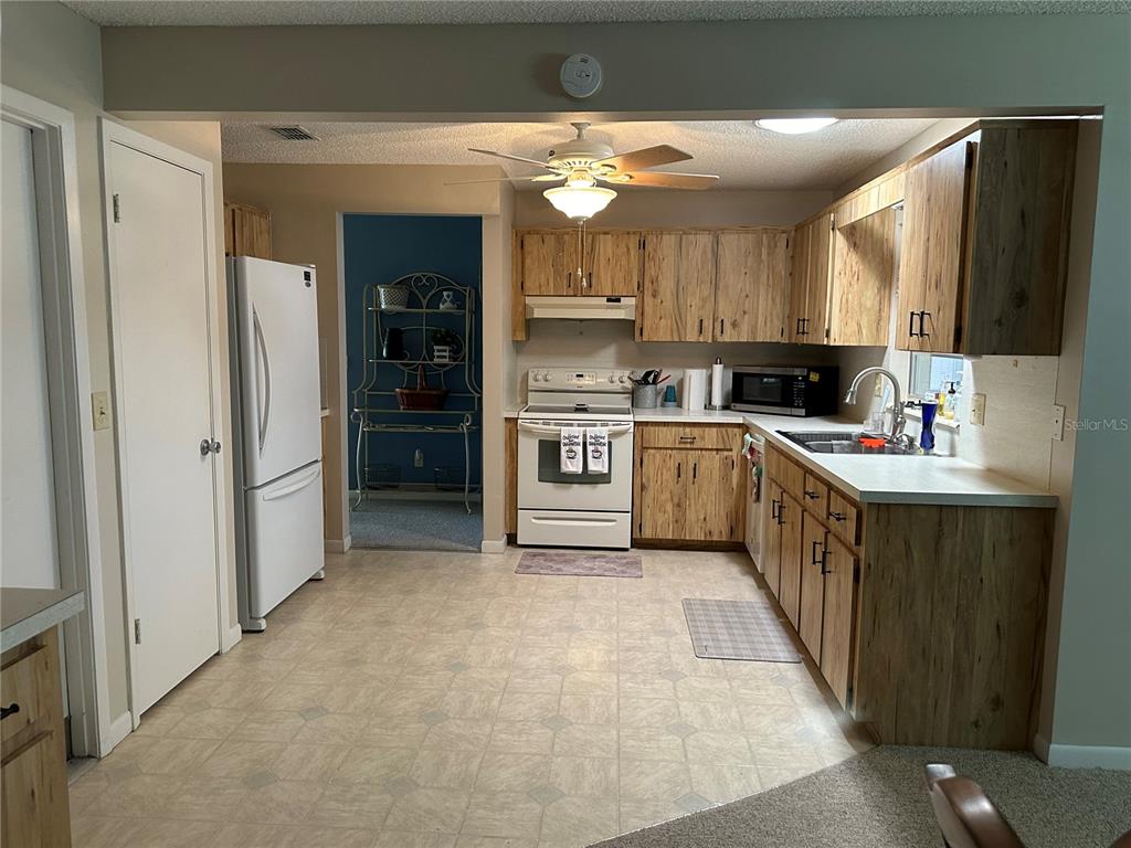 8680 Southwest 94 Lane, Unit G Ocala, FL 34481 - Photo 12 of 24 a kitchen with a sink a refrigerator and cabinets