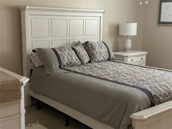 a large bed sitting in a bedroom next to a window