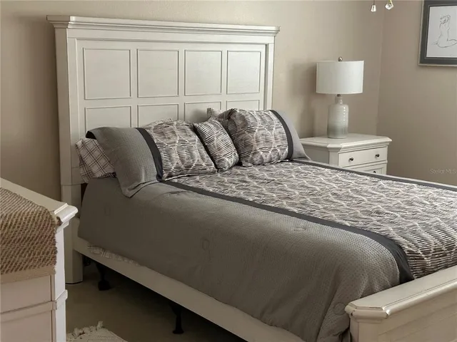 a large bed sitting in a bedroom next to a window