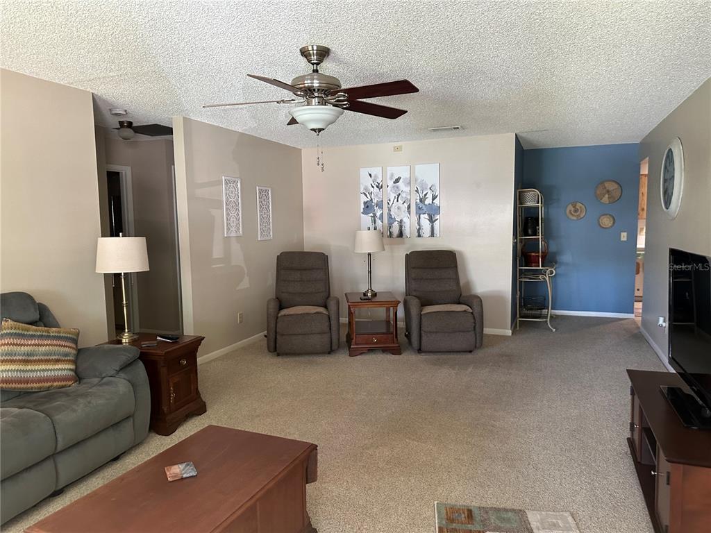 8680 Southwest 94 Lane, Unit G Ocala, FL 34481 - Photo 2 of 24 a living room with furniture a lamp and a flat screen tv