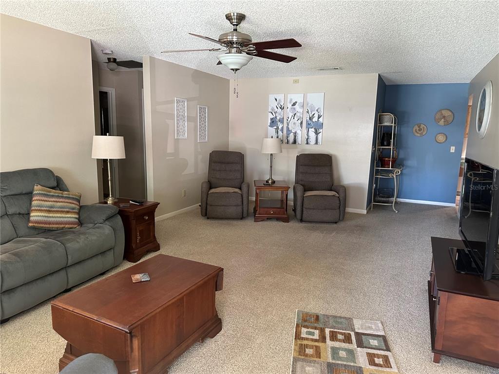 8680 Southwest 94 Lane, Unit G Ocala, FL 34481 - Photo 3 of 24 a living room with furniture a fireplace and a flat screen tv