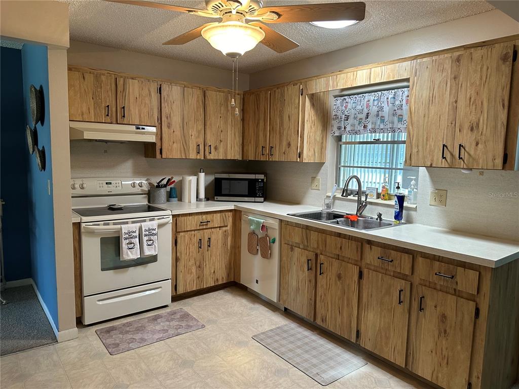 8680 Southwest 94 Lane, Unit G Ocala, FL 34481 - Photo 9 of 24 a kitchen with cabinets appliances a sink and a window