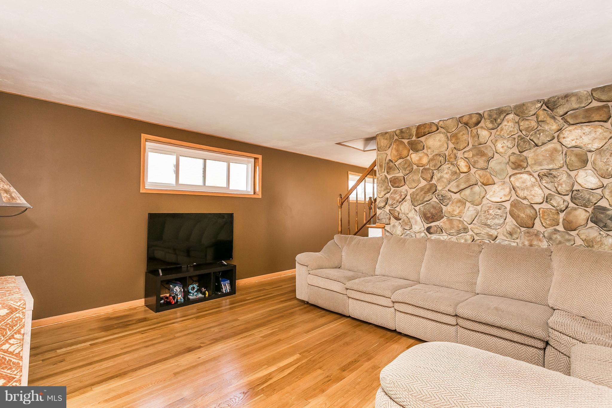 8511 Kings Ridge Road Baltimore, MD 21234 - Photo 5 of 30 a living room with furniture a flat screen tv and a toilet