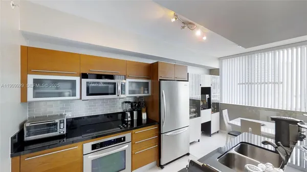 a kitchen with stainless steel appliances a refrigerator sink and microwave