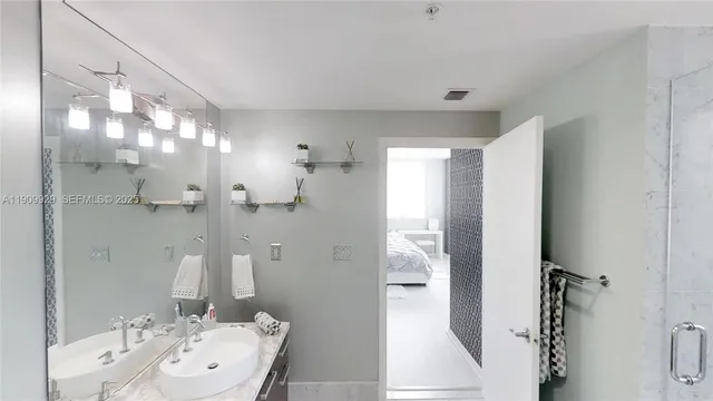 a bathroom with a double vanity sink mirror and shower