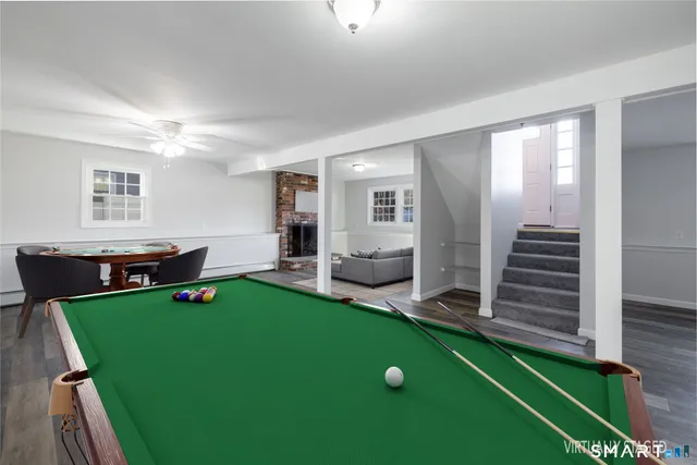 a living room with furniture pool table and window