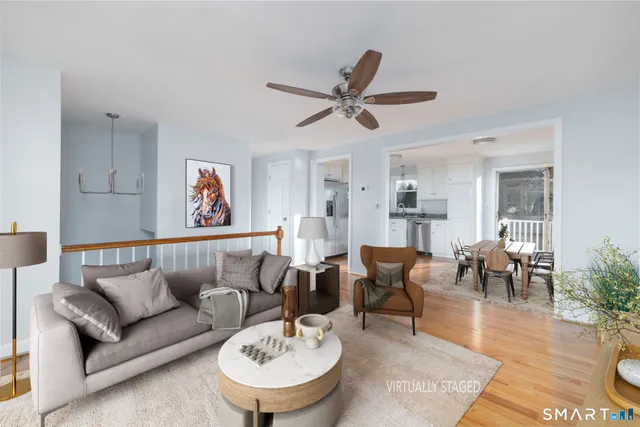 a living room with furniture and a dining table with wooden floor