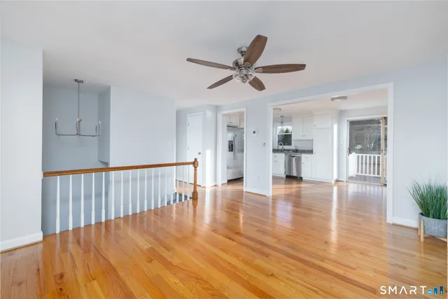 a view of empty room with wooden floor and window