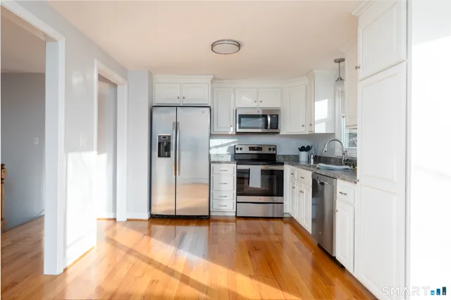 a kitchen with stainless steel appliances a refrigerator and a stove top oven