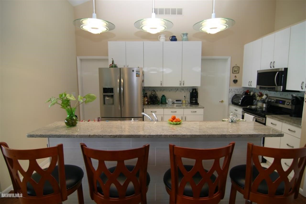 8477 West Mound Road Lena, IL 61048 - Photo 21 of 25 a kitchen with stainless steel appliances a table chairs and a refrigerator