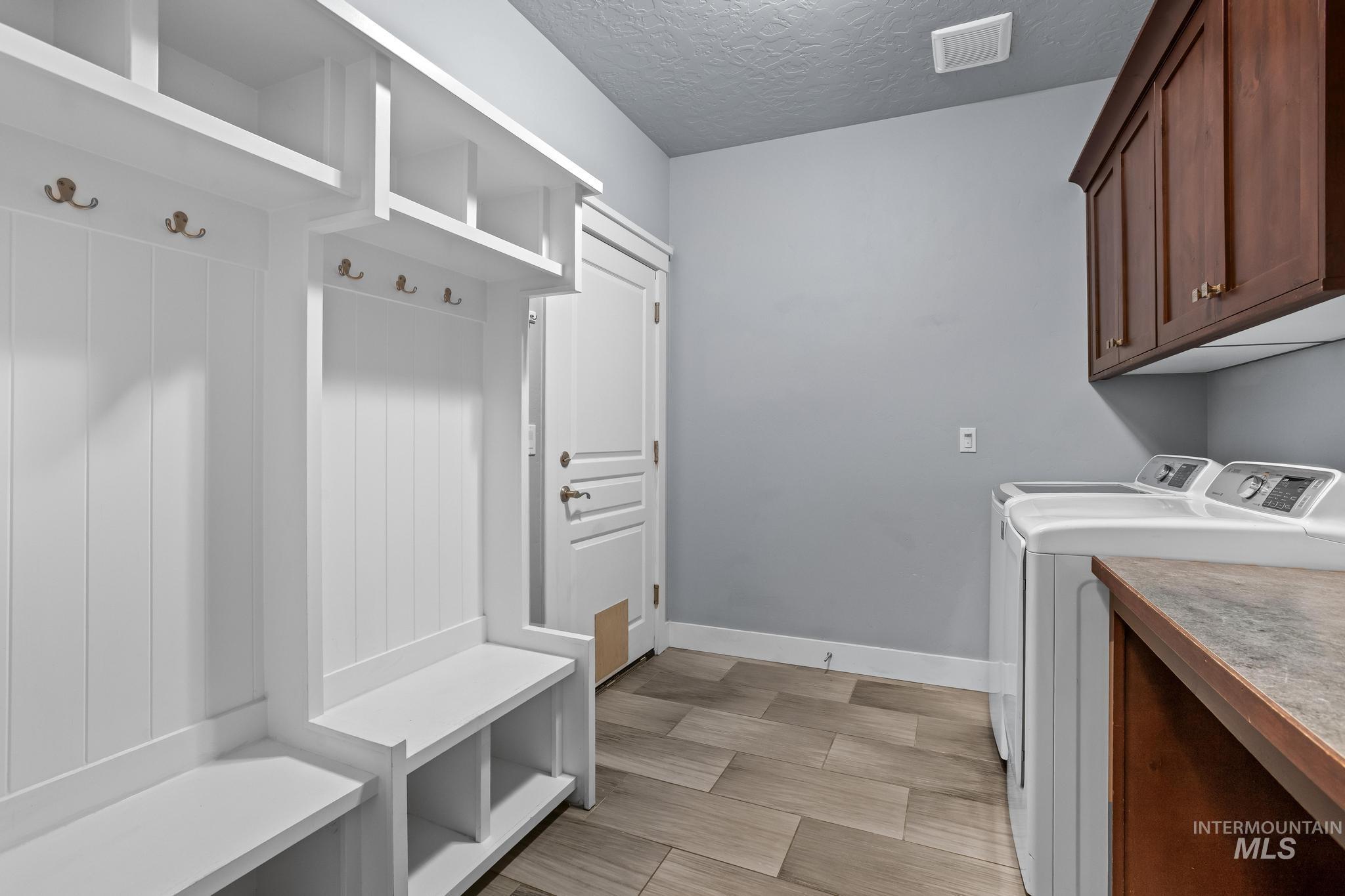 2681 East Rhyolite Court Nampa, ID 83686 - Photo 32 of 48 Mudroom featuring built-in white storage cubbies, integrated bench seating, and brass coat hooks