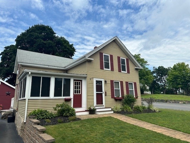 84 Lincoln Street Hudson, MA 01749 - Photo 2 of 26 a front view of a house with a yard and garage
