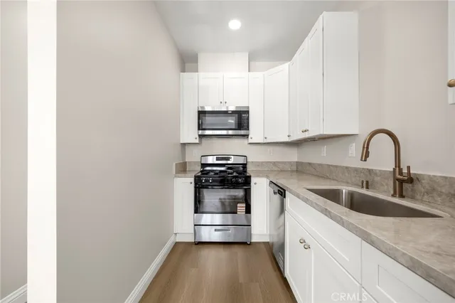 a kitchen with stainless steel appliances granite countertop a sink and cabinets
