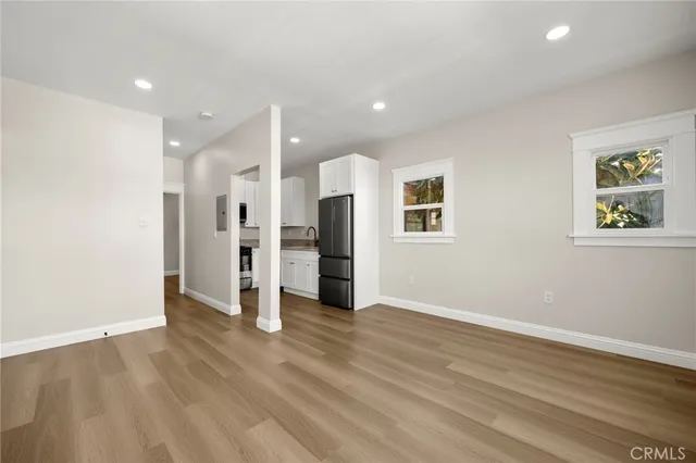 a view of a kitchen with wooden floor and windows