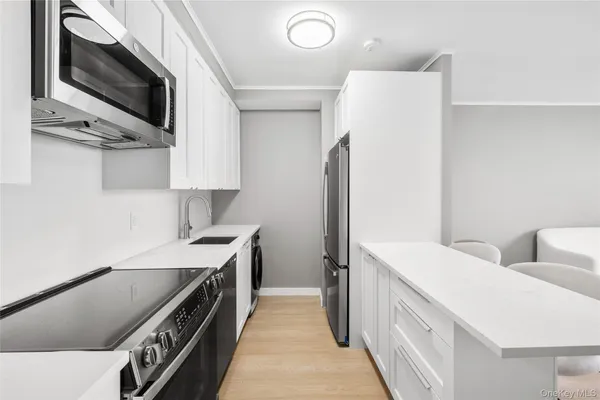 a kitchen with stainless steel appliances a stove microwave and refrigerator