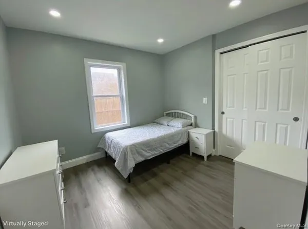 a spacious bedroom with a bed and a wooden floor