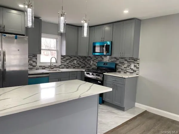 a kitchen with stainless steel appliances a sink stove and refrigerator