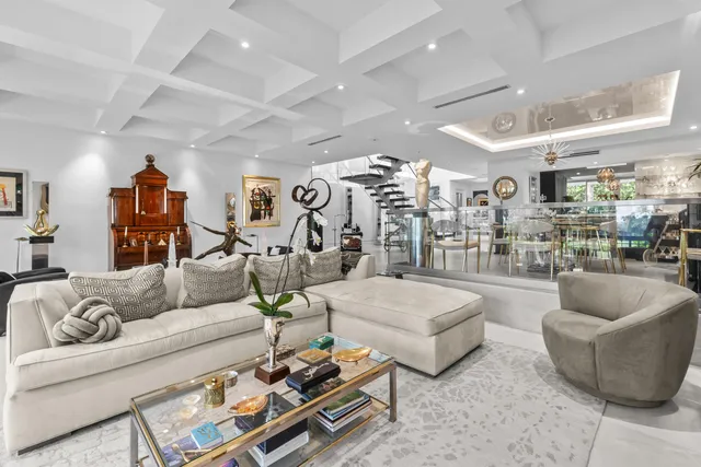 a view of a dining room and livingroom with furniture a kitchen appliances and a chandelier