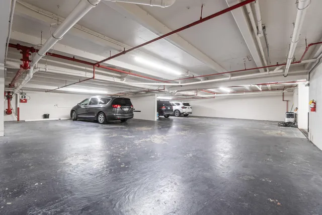 a view of a street with potted plants and large trees