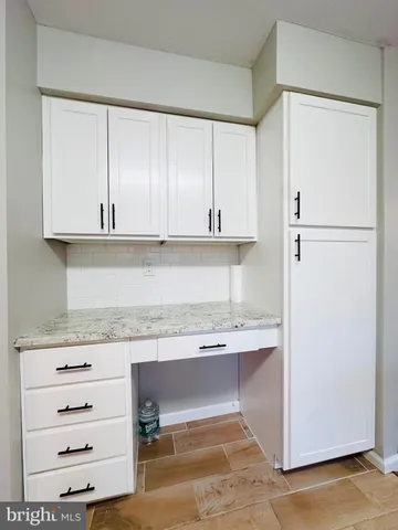 a kitchen with stainless steel appliances white cabinets and a refrigerator