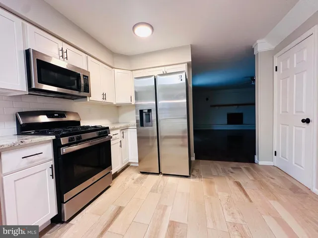 a kitchen with stainless steel appliances granite countertop a stove a microwave and a refrigerator