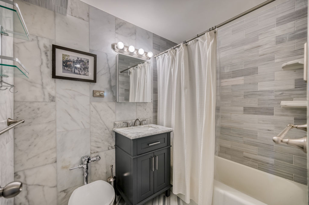 6030 North Sheridan Road, Unit 809 Chicago, IL 60660 - Photo 14 of 17 a bathroom with a toilet a sink and a shower curtain