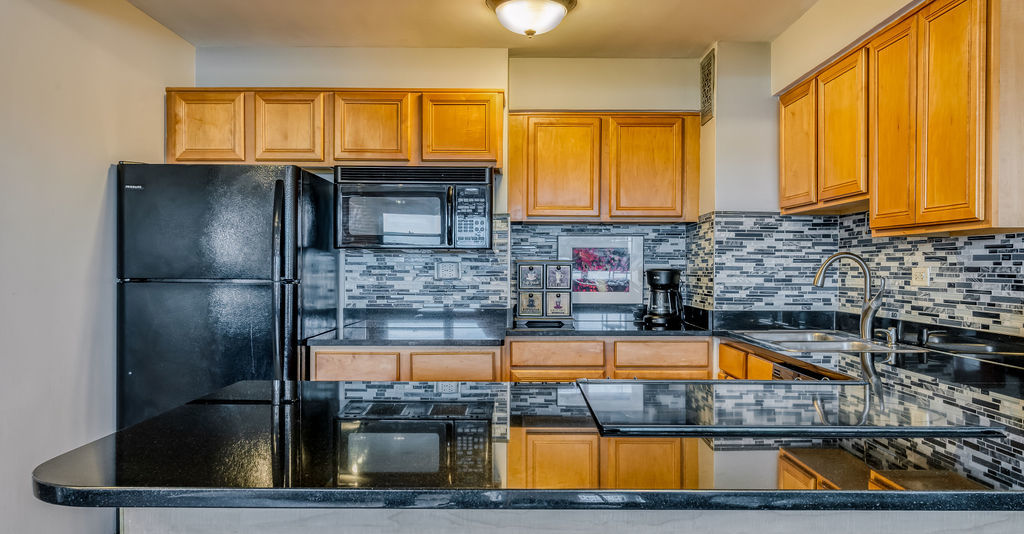 6030 North Sheridan Road, Unit 809 Chicago, IL 60660 - Photo 9 of 17 a kitchen with stainless steel appliances granite countertop a sink a counter top space and cabinets