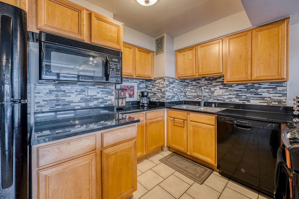 6030 North Sheridan Road, Unit 809 Chicago, IL 60660 - Photo 10 of 17 a kitchen with granite countertop cabinets stainless steel appliances and a counter space