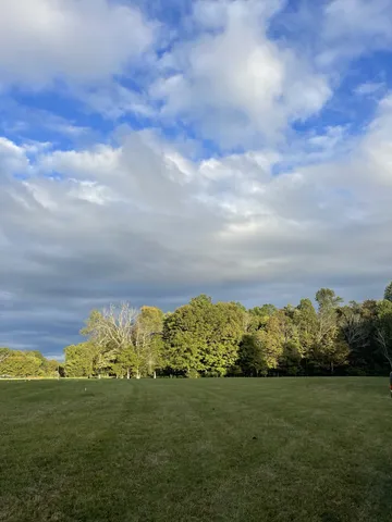 a view of a big yard with lots of green space and mountain view