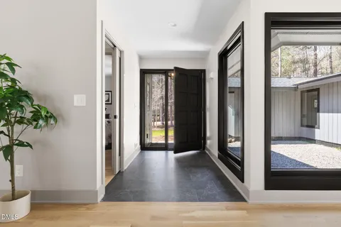 a kitchen with stainless steel appliances granite countertop a sink a stove a dining table and chairs with wooden floor