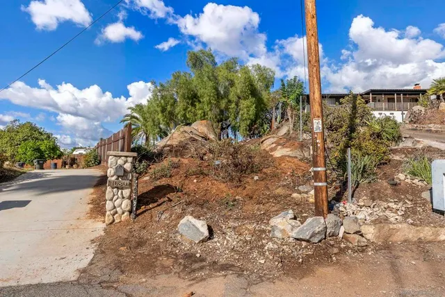 a view of backyard with potted plants and wooden fence