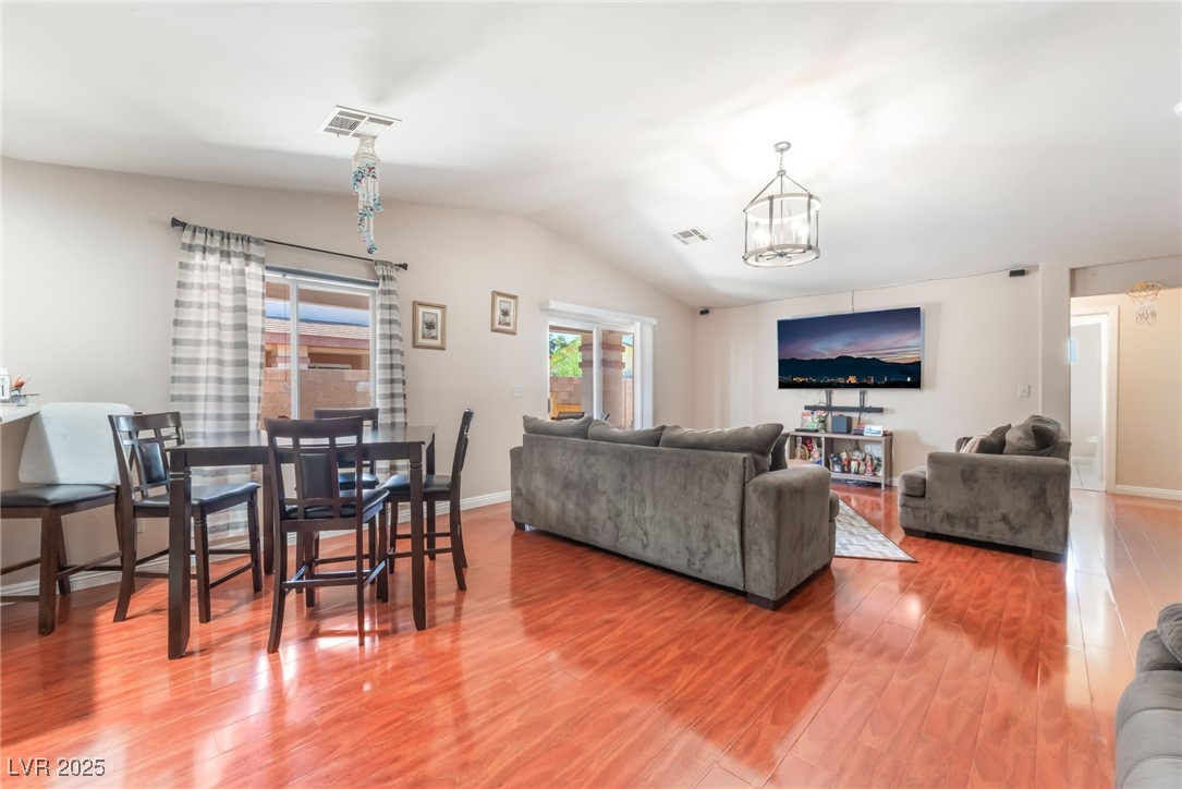 4656 East Desert Inn Road Las Vegas, NV 89121 - Photo 89 of 98 4654 E DI Living room featuring lofted ceiling, a chandelier, and wood finished floors
