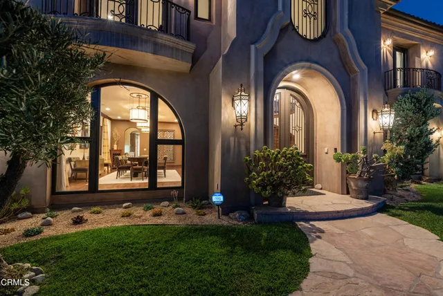 a view of a house with potted plants and more windows