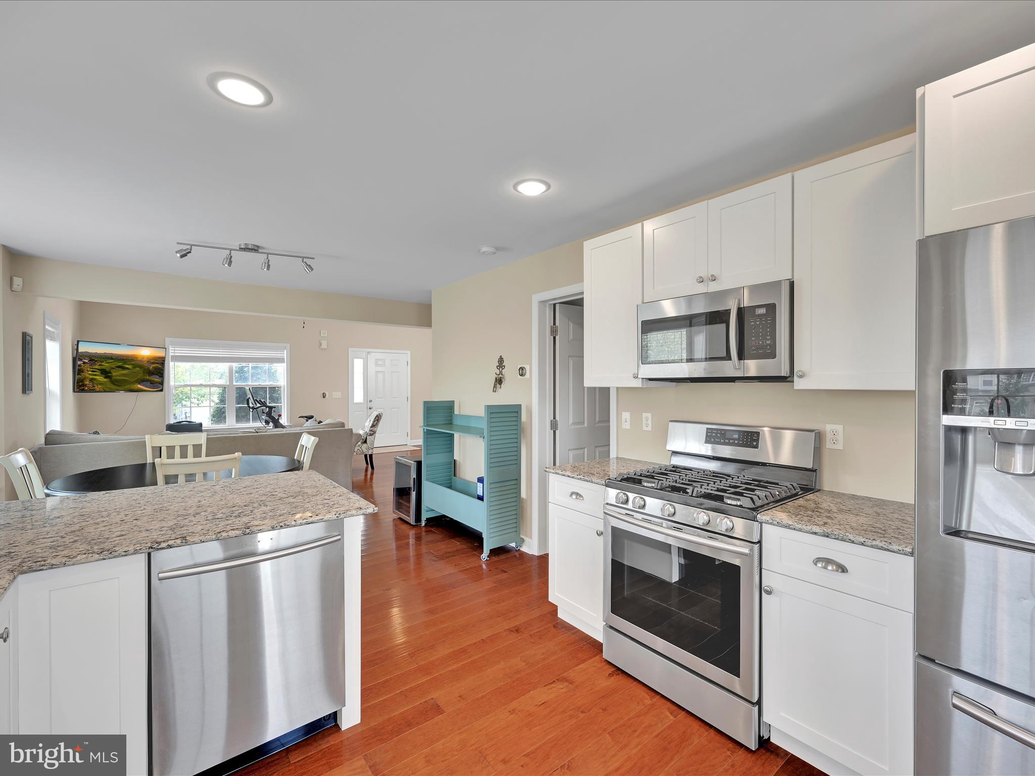 623 Courthouse Circle Lititz, PA 17543 - Photo 12 of 32 a kitchen with stainless steel appliances kitchen island granite countertop a stove a sink a refrigerator and white cabinets with wooden floor