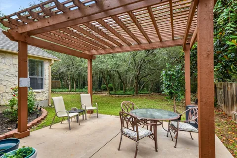 a view of a patio with a table chairs and a yard