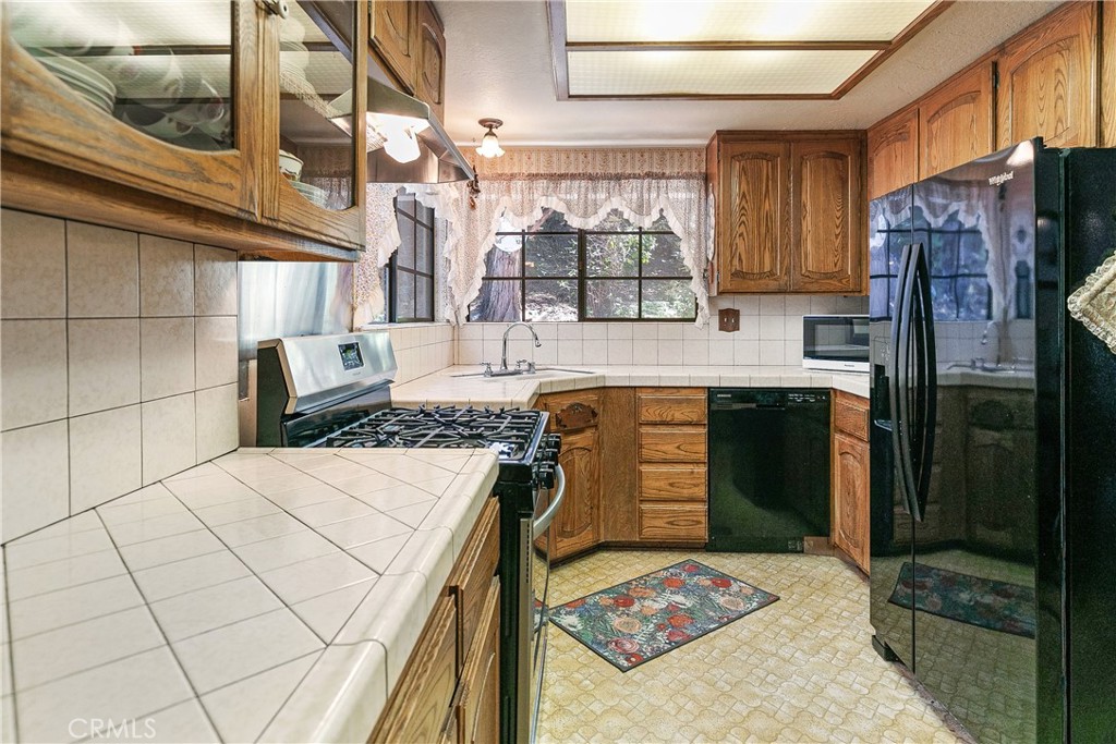 329 Grass Valley Road Lake Arrowhead, CA 92352 - Photo 12 of 31 a kitchen that has a refrigerator and a stove
