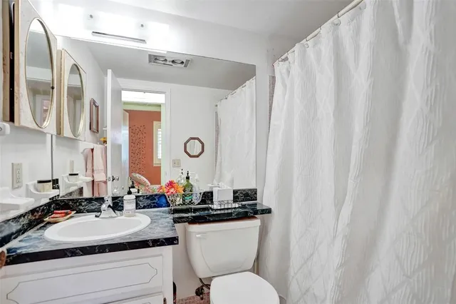 a bathroom with a double vanity sink toilet and a mirror