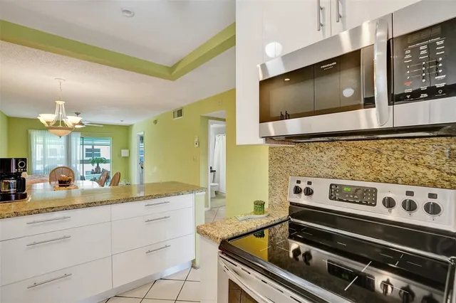 a kitchen with stainless steel appliances kitchen island granite countertop a stove and a microwave