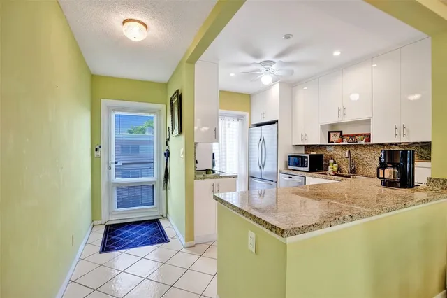 a kitchen with stainless steel appliances granite countertop a refrigerator and a sink