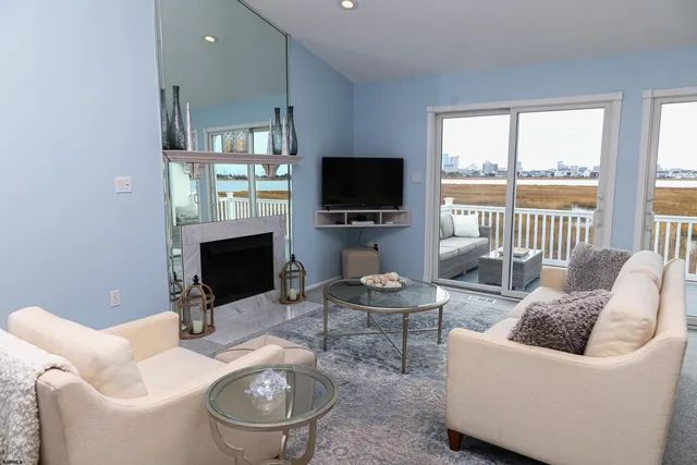 a living room with furniture a flat screen tv and a fireplace