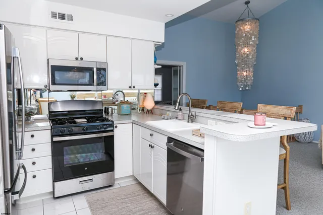a living room with stainless steel appliances kitchen island granite countertop furniture and a window