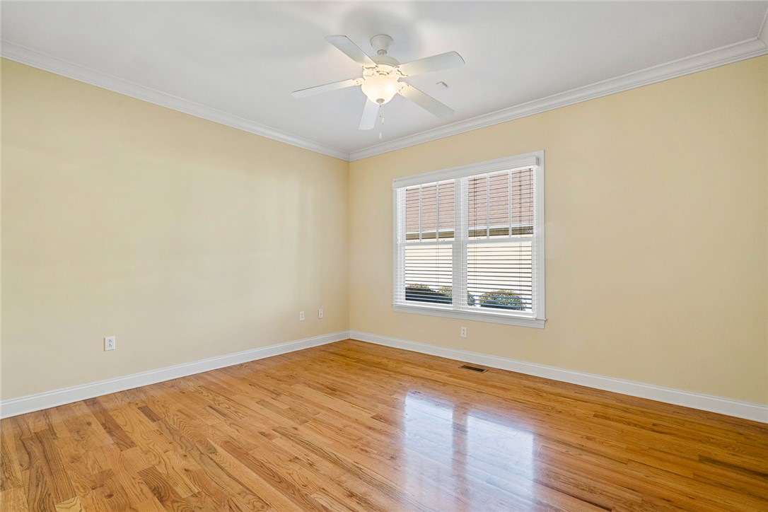 16 Oleander Drive Anderson, SC 29621 - Photo 28 of 37 Natural light illuminates rich hardwood floors, complemented by a contemporary ceiling fan and crisp crown molding.