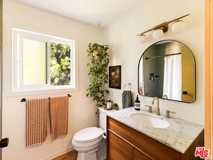 a bathroom with a granite countertop toilet a sink and a mirror