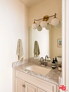 a bathroom with a granite countertop sink and a mirror