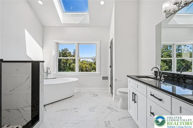 a bathroom with a granite countertop sink toilet and bathtub