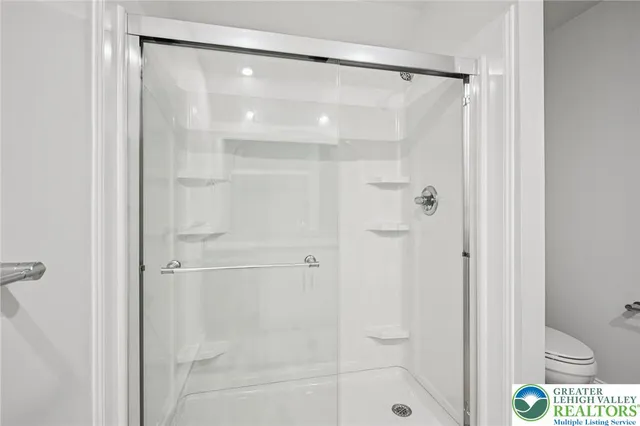 a bathroom with a shower and a glass shower door