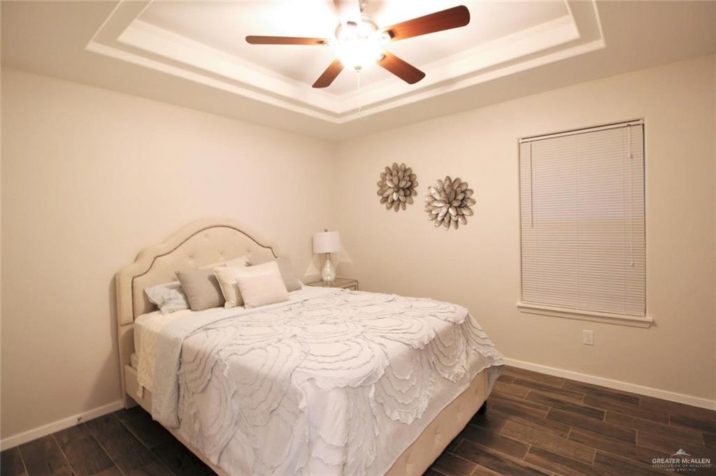 1506 Deer Hills, Unit 3 Edinburg, TX 78541 - Photo 8 of 11 Bedroom featuring wood tiled floors, a tray ceiling, and a ceiling fan