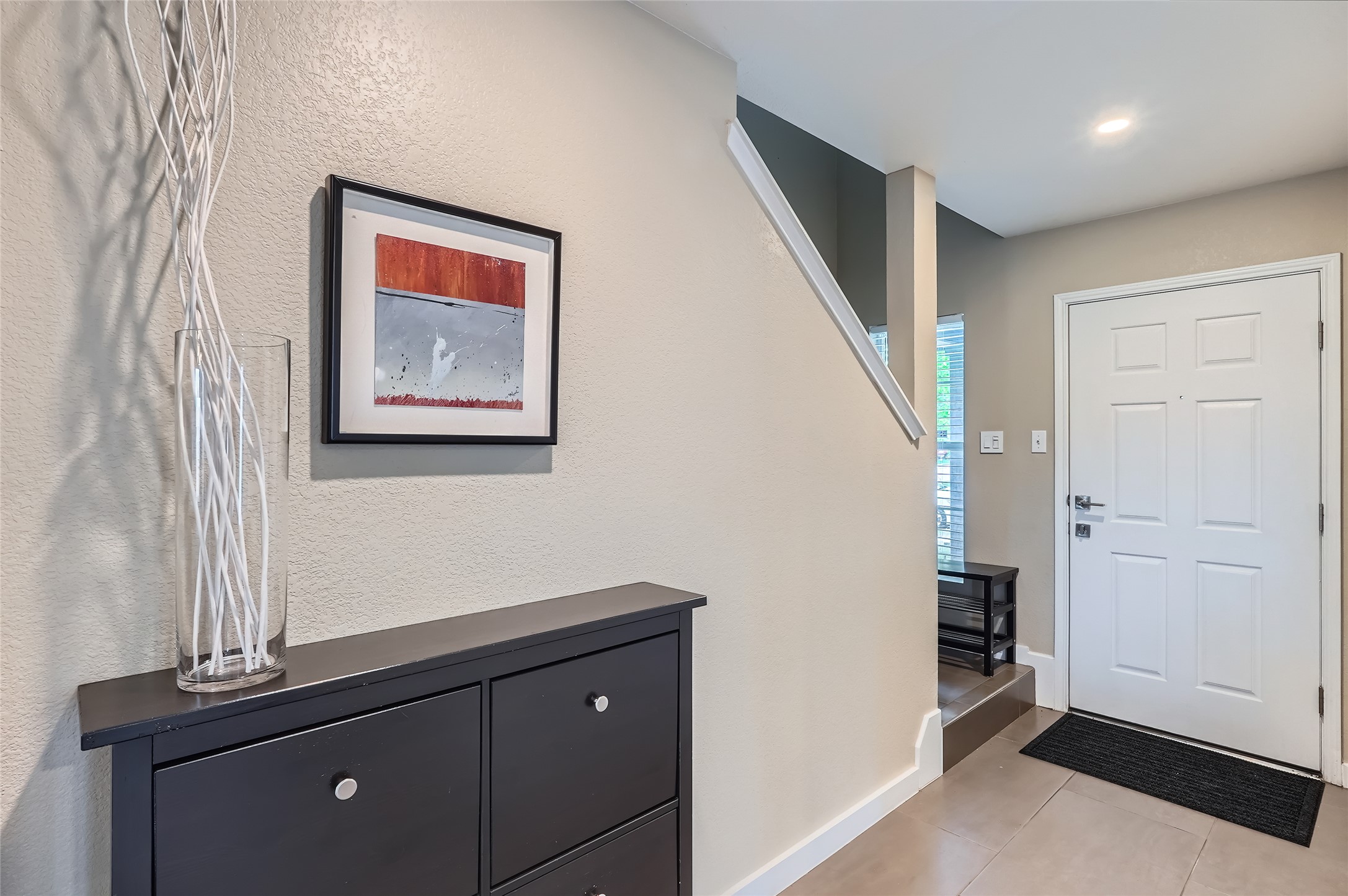 18021 Prairie Verbena Lane Elgin, TX 78621 - Photo 14 of 33 A well-lit entry with sleek tile flooring and a view of the ascending staircase.